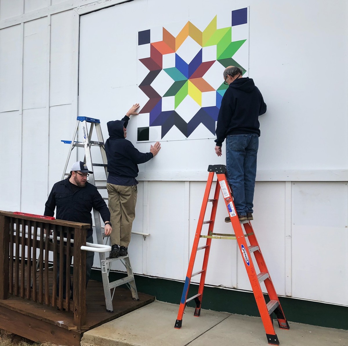 Parks & Recreation staff installing the Carpenter's Wheel quilt square at Franklin Park Arts Center in Purcellville